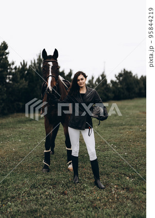 A young woman and friendship with a horse. A young woman and friendship with a horse. 95844219