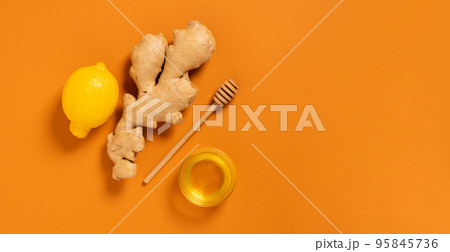 Fresh ginger root lemon honey orange background. Alternative medicine vegetarianism Fresh ginger root lemon honey orange background. Alternative medicine vegetarianism 95845736