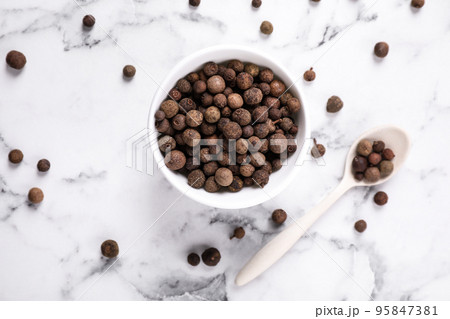 Black peppercorns on white marble table, flat lay Black peppercorns on white marble table, flat lay 95847381