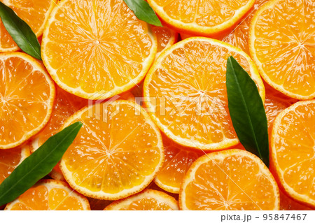 Slices of fresh ripe tangerines and leaves as background, top view. Citrus fruit Slices of fresh ripe tangerines and leaves as background, top view. Citrus fruit 95847467