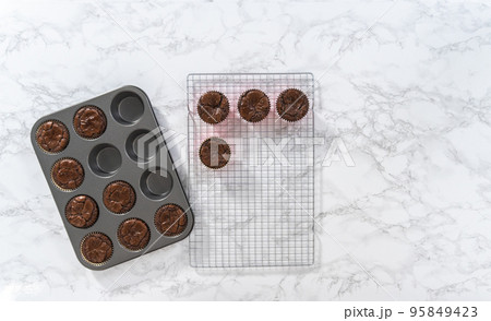 Flat lay. Cooling freshly baked chocolate peppermint cupcakes on a kitchen counter. Flat lay. Cooling freshly baked chocolate peppermint cupcakes on a kitchen counter. 95849423