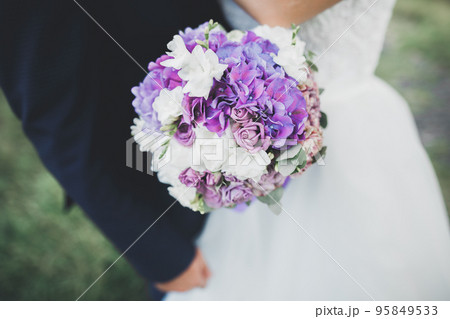 Bride holding big and beautiful wedding bouquet with flowers Bride holding big and beautiful wedding bouquet with flowers 95849533