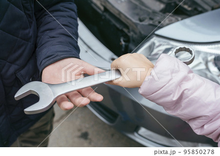 close up of two mechanics sharing metal spanner close up of two mechanics sharing metal spanner 95850278