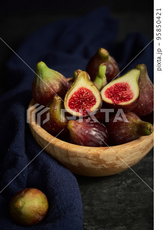 juicy fig berries in a wooden bowl juicy fig berries in a wooden bowl 95850421