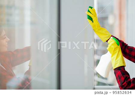 Young asian woman washing window with sponge. 95852634