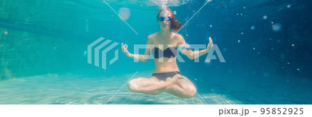 young woman in black bikini in yoga position underwater in diving aquarium, full body shot, front view BANNER, long format 95852925