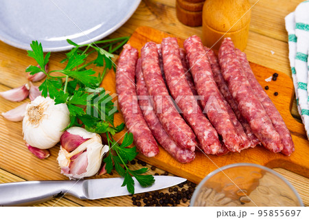 Delicious longaniza from minced meat on wooden surface, pork sausage Delicious longaniza from minced meat on wooden surface, pork sausage 95855697