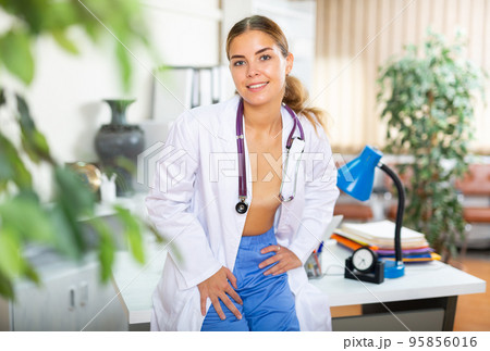 Young female doctor in unbuttoned gown Young female doctor in unbuttoned gown 95856016