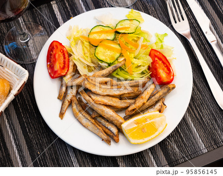 Appetizer cooked anchovies with vegetable garnish 95856145