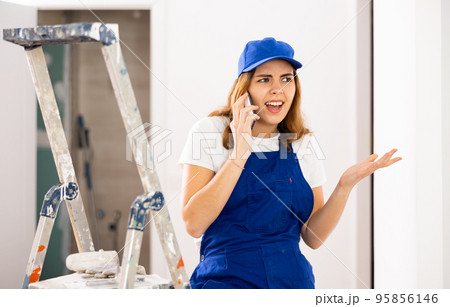Young woman builder having quarrel during phone call Young woman builder having quarrel during phone call 95856146