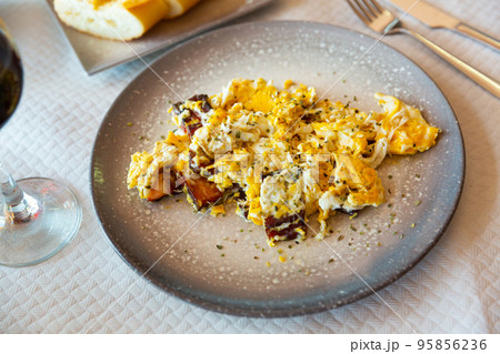 Traditional Spanish scrambled eggs with bacon (revuelto con cerdo) 95856236
