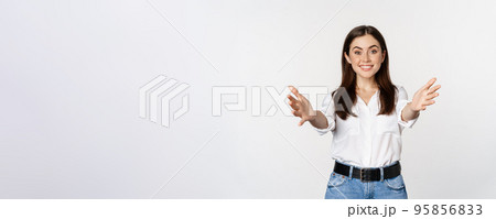 Enthusiastic laughing woman, smiling and stretching out arms forward, welcome you, greeting, standing over white background 95856833
