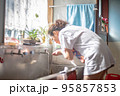 朝に洗面所で顔を洗う女性 95857853