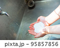 水道で泡ハンドソープで手を洗う人の手 95857856