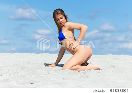 Graceful woman in bikini on sandy beachの写真素材 [95858802
