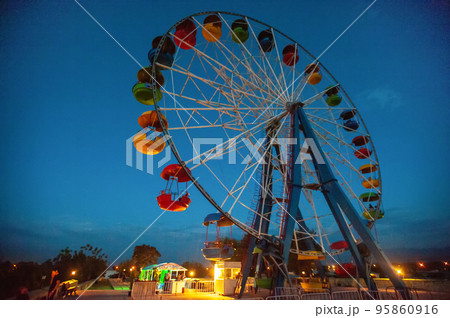 A attraction ferris wheel in the amusement park at night 95860916