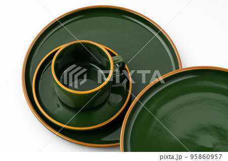 A set of dark green ceramic tableware with orange outlines on a white background A set of dark green ceramic tableware with orange outlines on a white background 95860957