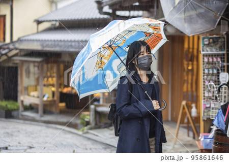 雨の日に傘をさして外出するシニア女性 95861646