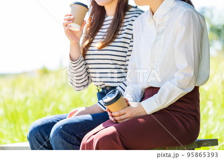 公園でコーヒーを飲む若い大学生の女性二人 公園でコーヒーを飲む若い大学生の女性二人 95865393