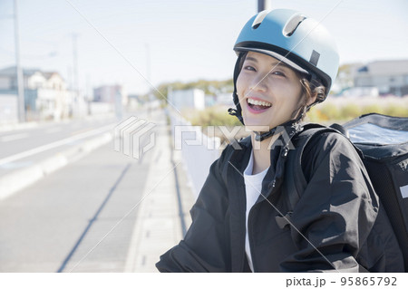 フードデリバリーイメージ　自転車でデリバリーする若い女性 シェアデリ 95865792