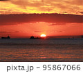 茜色に染まる瀬戸内海の夕陽の中を行き交う船の群れ 95867066