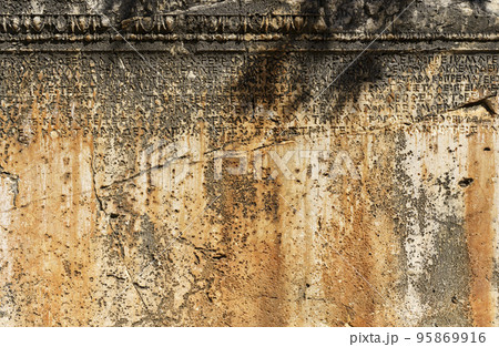 Ancient Greek antique text and inscriptions on the stone wall of the temple. Ancient Greek culture, alphabet and writing background, history concept. Ancient Greek antique text and inscriptions on the stone wall of the temple. Ancient Greek culture, alphabet and writing background, history concept. 95869916