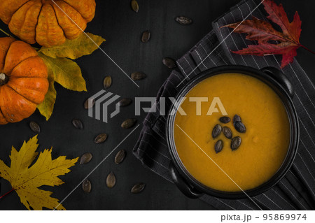 Pumpkin puree soup on a dark background in autumn style. Pumpkin puree soup on a dark background in autumn style. 95869974