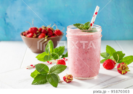 Strawberry milkshake or smoothie on a white wooden background. Healthy juicy vitamin drink diet or vegan food concept. 95870303