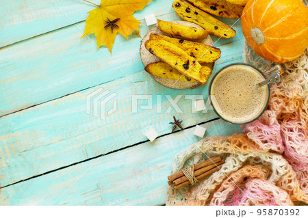 Autumn background baking. Freshly baked raisins and cinnamon biscotti and a cup of cappuccino coffee on a table in a rustic style. Top view flat lay background, copy space. 95870392