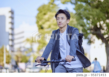 自転車に乗るジャケットを着た若い日本人の男性 95871453