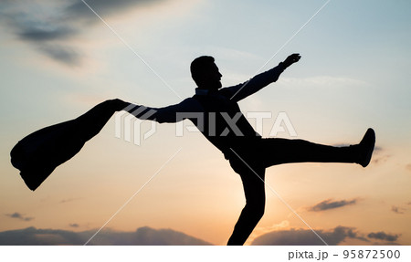 dancing man silhouette with jacket against sunset sky, freedom dancing man silhouette with jacket against sunset sky, freedom 95872500