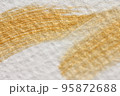 水彩紙に描いた金色のブラシストロークの抽象的背景 95872688
