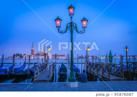 Gondole docked by wooden mooring poles in grand canal, Ethereal Venice, Italy Gondole docked by wooden mooring poles in grand canal, Ethereal Venice, Italy 95876087