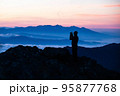 山頂で日の出を眺める登山者2 95877768