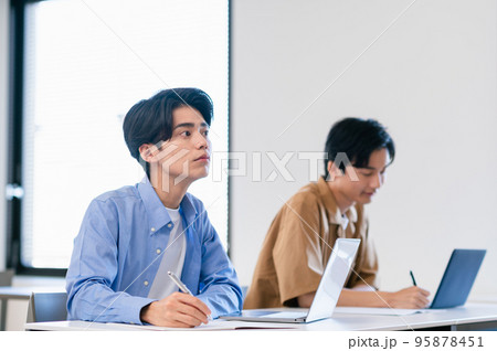 教室で講義を受ける男子大学生 教室で講義を受ける男子大学生 95878451