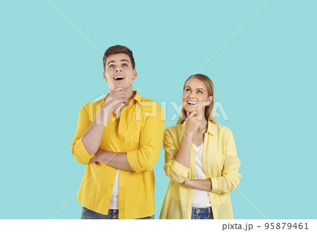 Happy young couple looking up and smiling while thinking about their future holiday 95879461