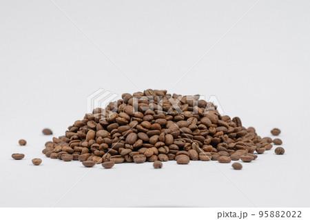 A pile of coffee beans on a white background, place for advertising. A pile of coffee beans on a white background, place for advertising. 95882022