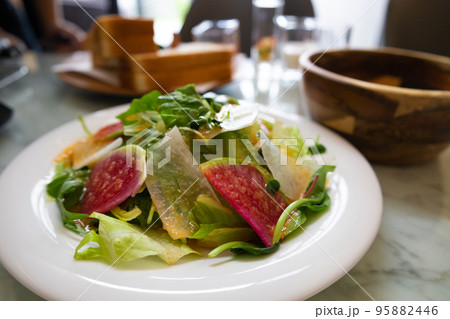 日差しが降り注ぐ爽やかなダイニングで前菜のグリーンサラダとサンドイッチの朝食（千葉県） 95882446