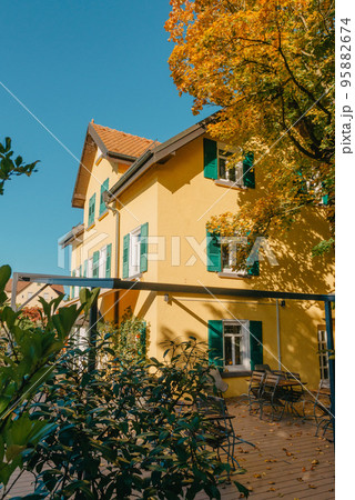 Image of a empty coffee tables arranged in backyard of a house. Autumn in Germany, Europe. Outdoor table in street cafe. autumn outdoor cafe wooden furniture old europe. Autumn photo of old-fashioned Image of a empty coffee tables arranged in backyard of a house. Autumn in Germany, Europe. Outdoor table in street cafe. autumn outdoor cafe wooden furniture old europe. Autumn photo of old-fashioned 95882674