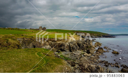 Overcast cloudy sky over the rocky coast of Ireland. Beautiful nature of northern Europe. Green fields on the coast. Aerial photo. Overcast cloudy sky over the rocky coast of Ireland. Beautiful nature of northern Europe. Green fields on the coast. Aerial photo. 95883063