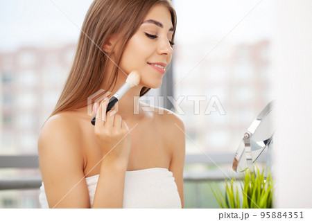Woman using mascara on eyelash in bathroom in the morning time. Woman using mascara on eyelash in bathroom in the morning time. 95884351
