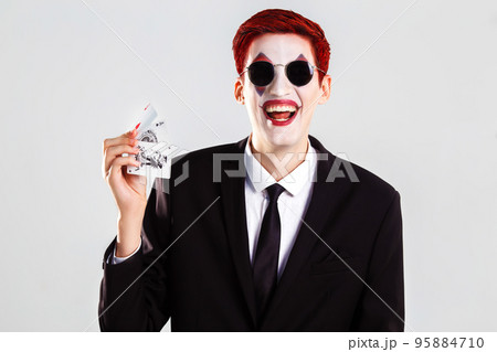 A young boy with an artistic make up joker . gamble and casino concept. studio shot. white background . A young boy with an artistic make up joker . gamble and casino concept. studio shot. white background . 95884710