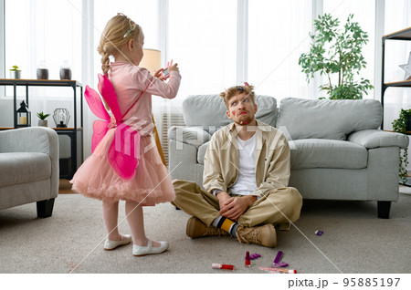 Daughter making shot of father with funny makeup 95885197