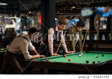 Company of handsome young guy playing in pool 95885294