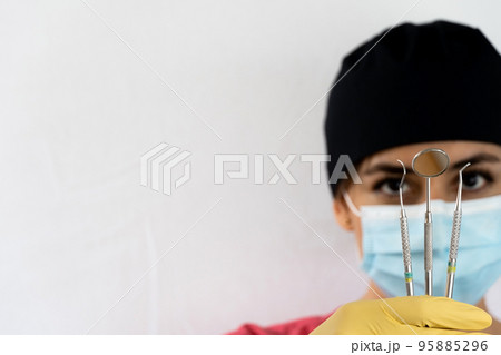 young female dentist holding dental instruments in her hand 95885296