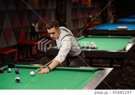 Portrait of man playing billiards Portrait of man playing billiards 95885297