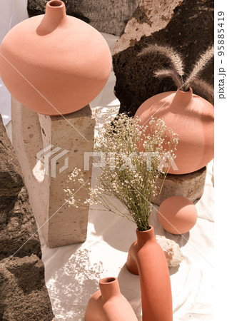 Earthenware vases and objects, pastel terracotta colors, with still life like vegetation 95885419