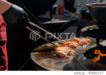 Chef cooking fried chicken meat pieces on brazier with hot flame - close up 95885717