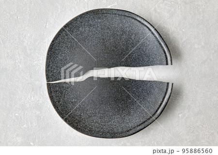 Broken plate on a light gray concrete table. Broken dreams Broken plate on a light gray concrete table. Broken dreams 95886560