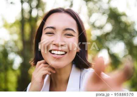 Genuine people. Portrait of asian woman laughing and smiling, walking in park, feeling joy and positivity Genuine people. Portrait of asian woman laughing and smiling, walking in park, feeling joy and positivity 95886570